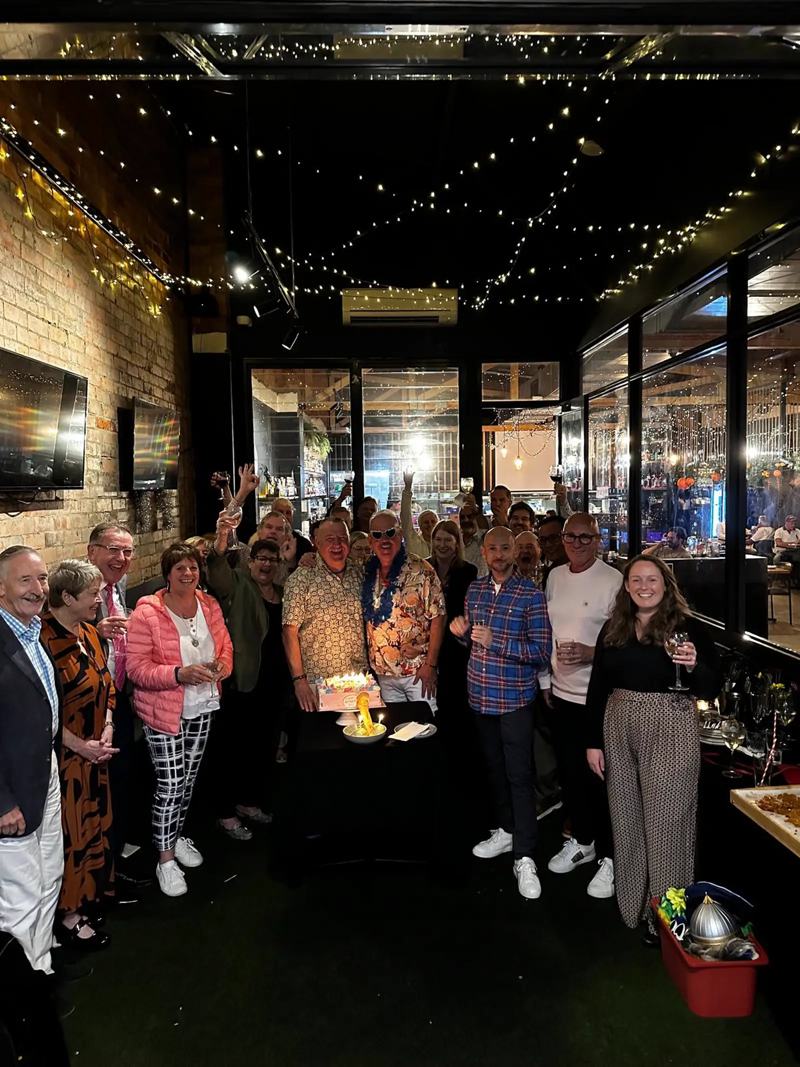A birthday group gathered around the cake in the Private Room