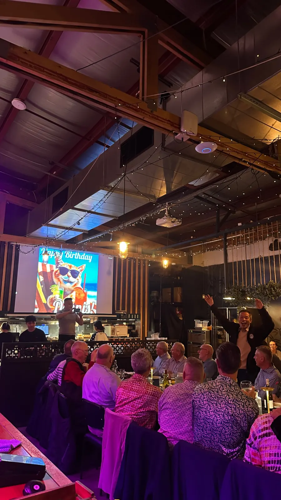 A birthday celebration with a slideshow on the big screen