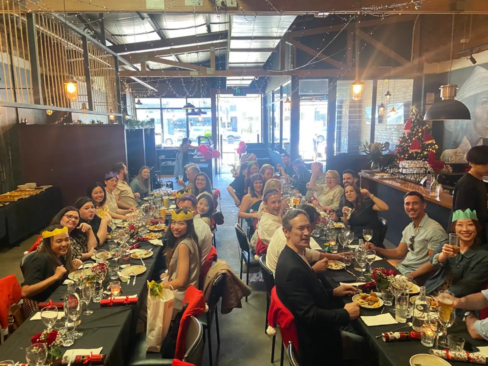 A Christmas party in paper crowns along long tables in the dining room