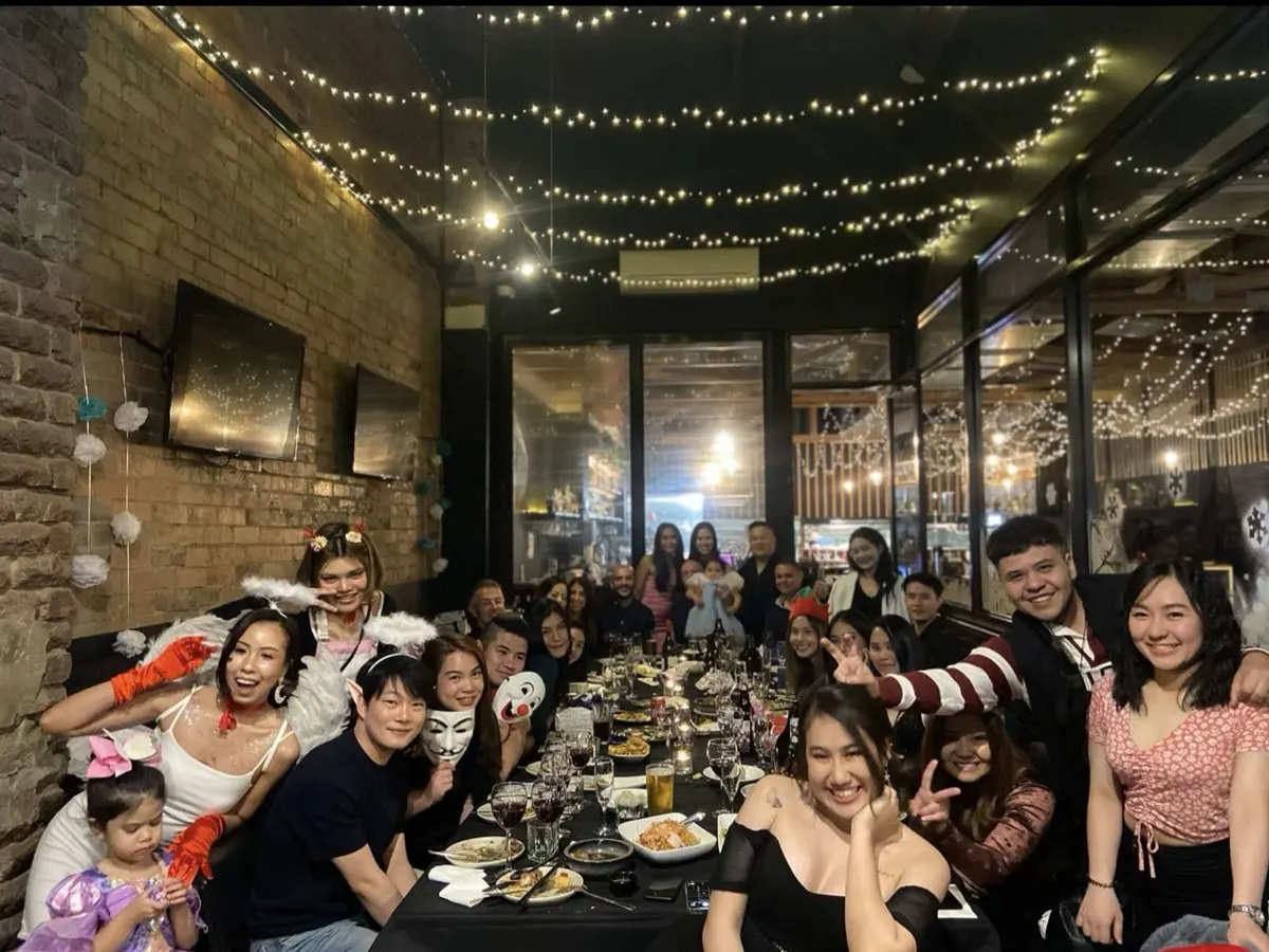 A birthday group around the long table in the Private Room under fairy lights